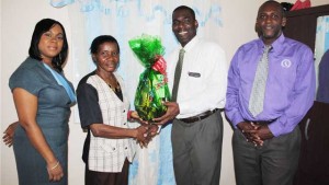 Mr Carlton Pogson, Acting General Manager, Development Bank of St. Kitts and Nevis (2nd right) presenting a ‘house-warming’ token to Mrs Esther Hodge. Looking on are Ms Danienne Brin (left) and Mr Patrice Ward.