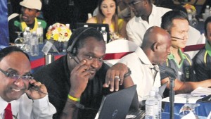 (From left) Guyana Amazon Warriors team manager Omar Khan and coach Carl Hooper consult each other, while Jamaica Tallawahs assistant coach Junior Bennett share ideas with Tallawahs owners Manish Patel and Ron Parikh during the CPL player draft at the Terra Nova Hotel in Kingston yesterday. (PHOTO: KARL MCLARTY)