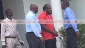 CEO of Phoenix Airways Neville Gumbs (second right) was arrested by police at his Hastings, Christ Church office yesterday. (GP)