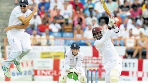 England’s captain Alistair Cook (left) leaps out of the way of a Marlon Samuels drive on the first day of the second Test between West Indies and England at the National Cricket Stadium, yesterday. (PHOTO: WICB MEDIA/RANDY BROOKS)