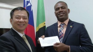 Taiwan’s Resident Ambassador His Excellency George Gow Wei Chiou (left) presents cheque to Honourable Shawn Richards                              (right) Minister of Education, Youth, Sports and Culture.