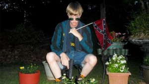 This undated image that appeared on Lastrhodesian.com, a website being investigated by the FBI in connection with Charleston, S.C., shooting suspect Dylann Roof, shows Roof posing for a photo while holding a Confederate flag. The website surfaced online Saturday, June 20, 2015, and also contained a hate-filled 2,500-word essay that talks about white supremacy and concludes by saying the author alone will need to take action. (Lastrhodesian.com via AP) MANDATORY CREDIT