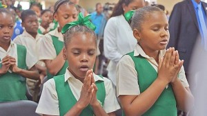 DEVOTION: Pupils of Febeau Government Primary School pray before yesterday’s official opening of their new school on Saddle Road, San Juan. —Photo: ANISTO ALVES