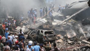 Firefighters and military personnel inspect the site where an Air Force cargo plane crashed in Medan, North Sumatra, Indonesia, tuesday, June 30, 2015. An Indonesian Air Force Hercules C-130 plane with 12 crew aboard has crashed into a residential neighborhood in the country's third-largest city Medan. (AP Photo/Gilbert Manullang)