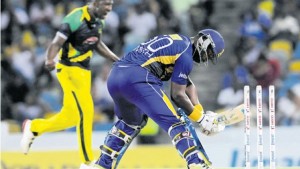 Barbados Tridents top scorer Dwayne Smith (right) reacts after being bowled for 56 by Jamaica Tallawahs’ Andre Russell during their CPL at Kensington Oval in Barbados on Tuesday. (PHOTO: CPL T20 LTD.2015)