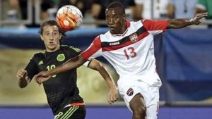 ACTION: Trinidad & Tobago's Cordell Cato (13) and Mexico's Andres Guardado chase the ball during the first half of a CONCACAF Gold Cup soccer match in Charlotte, N.C., Wednesday, July 15, 2015. (AP Photo/Gerry Broome)