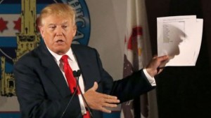 Republican presidential candidate Donald Trump casts a shadow against papers he used while speaking to members of the City Club of Chicago, Monday, June 29, 2015, in Chicago. (AP Photo/Charles Rex Arbogast)