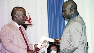 Outgoing president of the Jamaica Teachers’ Association Doran Dixon (left) passes the baton to new President Norman Allen at the Hilton Rose Hall in St James, Monday night. 