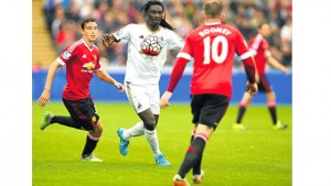 Manchester United’s Italian defender Matteo Darmian (left) and Manchester United’s English striker Wayne Rooney (right) challenge Swansea City’s French striker Bafetimbi Gomis during their English Premier League match at The Liberty Stadium in Swansea, south Wales, yesterday. Swansea won 2- 1. 