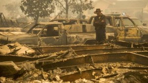 A cameraman surveys homes and vehicles destroyed by the Valley Fire in Middletown, California September 13, 2015.