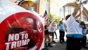 Protestor Genoveva Castillos holds a sign outside of a political rally for Republican presidential candidate Donald Trump in Dallas, Texas September 14, 2015. 