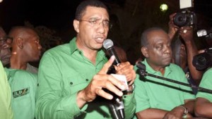 Andrew Holness delivering his victory speech to JLP supporters last night. Beside him is Derrick Smith.