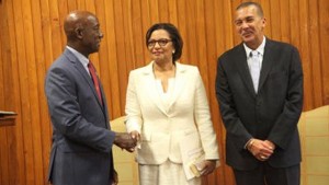 President Anthony Carmona, right, looks on as Prime Minister Keith Rowley congratulates the newest addition to the Ministry of National Security, Glenda Jennings-Smith, during a ceremony at the Office of the President, St Ann's, yesterday.