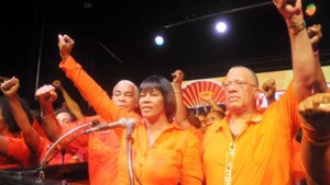 PNP President and Prime Minister Portia Simpson Miller, flanked by Finance Minister Dr Peter Phillips (right), Water and Climate Change Minister Robert Pickersgill and other candidates give the party’s clenched fist salute at last night’s rally.