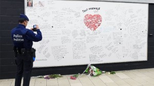 A policeman takes a picture of messages on a commemorative wall at the Maelbeek - Maalbeek metro station on its re-opening day on April 25, 2016 in Brussels A policeman takes a picture of messages on a commemorative wall at the Maelbeek - Maalbeek metro station on its re-opening day on April 25, 2016 in Brussels