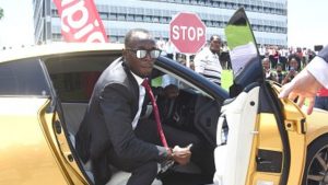 Usain Bolt exiting his Nissan sports car upon arrival at the Digicel headquarters in down town Kingston for his new job as Chief Speed Officer yesterday.