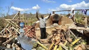 A man gestures as he stands in his destroyed home in Deson, Haiti. Photo: Hector Retamal