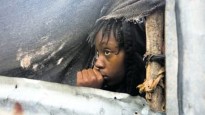  A girl watches as the authorities arrive to evacuate people from her house in Tabarre, yesterday.