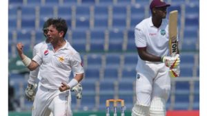 Pakistani spinner Yasir Shah (L) celebrates after taking the wicket of the West Indies' cricket captain Jason Holder (R) on the final day of the second Test between Pakistan and the West Indies at the Sheikh Zayed Cricket Stadium in Abu Dhabi on October 25, 2016. 