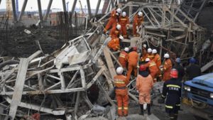 In this photo released by Xinhua News Agency, rescue workers look for survivors after a work platform collapsed at the Fengcheng power plant in eastern China's Jiangxi Province on Thursday