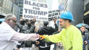 NEW YORK, United States - A construction worker exchanges a fist pound with a demonstrator, as pro-Trump supporters gather to cheer his election as president yesterday outside Trump Tower in New York. Trump’s triumph, declared after midnight, will end eight years of Democratic control of the White House. He’ll govern with a Republican-controlled Congress and lead a country deeply divided by his rancorous campaign against Hillary Clinton. 